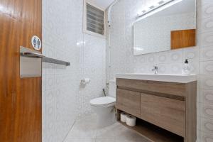 a bathroom with a toilet and a sink and a mirror at Tirreno 304 in La Pineda +16 photos