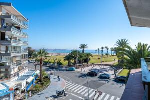 a view of a street with palm trees and the ocean at Tirreno 304 in La Pineda