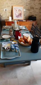a blue table with a plate of food on it at Chambres D'hôtes Le Fer À Cheval in Montreuil-sur-Maine