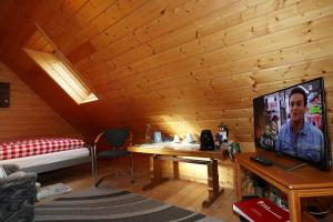 a room with a bed and a television in a cabin at Wohnung im Gästehaus Waldhüsle in Friedenweiler
