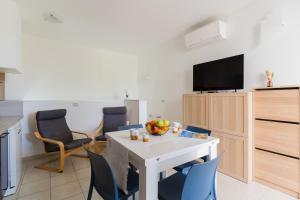 a kitchen and living room with a white table and chairs at Villa I Gabbiani a Otranto in Otranto