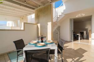 a dining room with a white table and chairs at Villa I Gabbiani a Otranto in Otranto