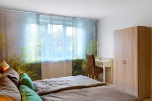 a bedroom with a bed and a desk and a window at Küstenglück in Wilhelmshaven