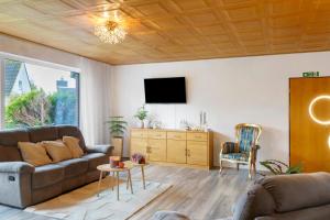 a living room with a couch and a tv at Küstenglück in Wilhelmshaven