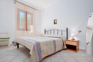 a bedroom with a bed and a table and a window at Villa Bianca in San Teodoro