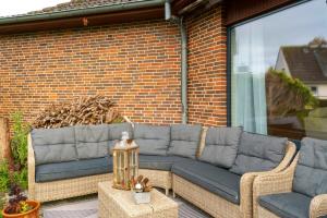 a patio with two couches on a brick wall at Küstenglück in Wilhelmshaven
