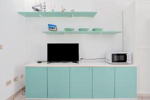 a desk with a tv and a microwave on it at Villa Bianca in San Teodoro