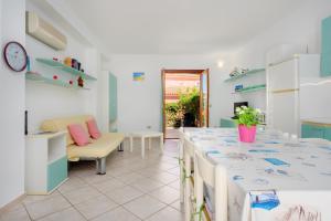 a kitchen with a long table and a chair at Villa Bianca in San Teodoro