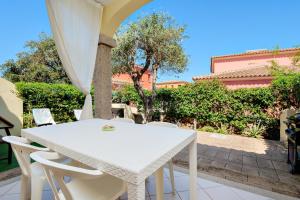 a white table and chairs on a patio at Villa Bianca in San Teodoro
