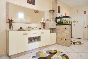 a kitchen with white cabinets and a tile floor at Casa laureta in Piombino