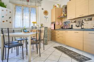 a kitchen with wooden cabinets and a table and chairs at Casa laureta in Piombino +12 photos
