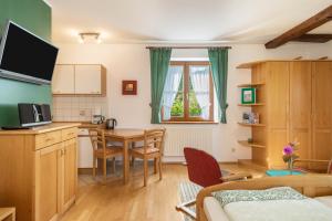 a room with a kitchen and a table with chairs at Ferienwohnung Risthof 2 in Owingen
