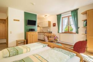 two beds in a room with a kitchen at Ferienwohnung Risthof 2 in Owingen