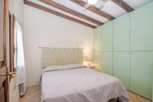 a bedroom with a white bed and a window at Residenza Conti Porto Istana in Porto Istana