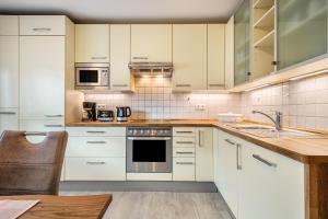 a kitchen with white cabinets and a sink at Mein lieber Schwan in Lindau