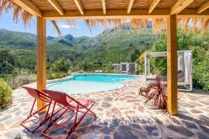 a pool with two chairs and a gazebo at Bed and Breakfast La Ruta Naranja in Adsubia