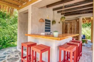 an outdoor kitchen with red stools at a counter at Bed and Breakfast La Ruta Naranja in Adsubia