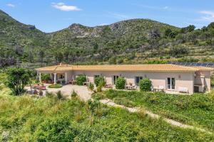 a house with mountains in the background at Bed and Breakfast La Ruta Naranja in Adsubia