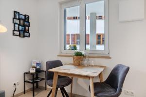 a table and chairs in a room with a window at Bodensee Apartment Lindau in Lindau +13 photos