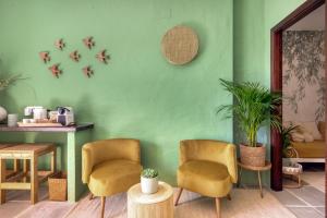 a green room with two chairs and a table at Bed and Breakfast La Ruta Naranja in Adsubia
