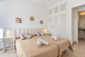 a bedroom with a large bed with two pillows at Bungalow Cala Dor 27 in Cala d´Or