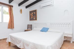 a white bedroom with a white bed and a window at Cala Serena Beach 6 in Felanitx
