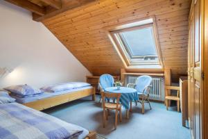 a bedroom with two beds and a table and chairs at Haus Kremeier in Kressbronn am Bodensee