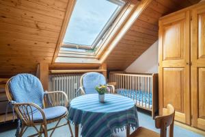 a room with a table and chairs and a skylight at Haus Kremeier in Kressbronn am Bodensee +14 photos