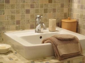 a bathroom sink with a towel and a faucet at La Campagne in Saint-Hubert