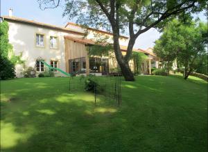 a house with a tree in the yard at La Campagne in Saint-Hubert