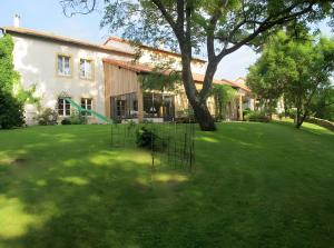 a house with a tree in the yard at La Campagne in Saint-Hubert