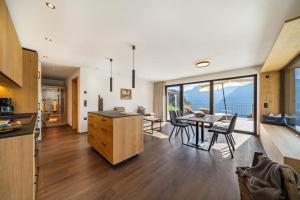 a kitchen and dining room with a table and chairs at Sunnseitn Lodge Exclusive Panorama in Moso