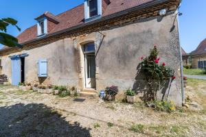 a house with a bunch of potted plants in front of it at Belle Ferme Périgourdine in Sainte-Foy-de-Longas