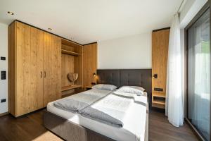 a bedroom with a large bed and wooden cabinets at Sunnseitn Lodge Exclusive Panorama in Moso