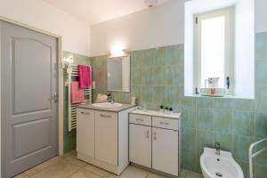 a bathroom with a sink and a toilet and a window at Belle Ferme Périgourdine in Sainte-Foy-de-Longas