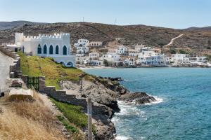 a group of white buildings on a hill next to the ocean at Gorgona in Loutra