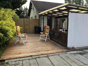 a wooden deck with two chairs and a pavilion at Haus im Grünen in Calau