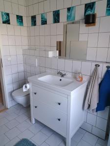a white bathroom with a sink and a toilet at Haus im Grünen in Calau
