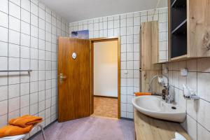 a bathroom with a sink and a wooden door at Haus am Markt Fewo 2 in Schöningen +16 photos