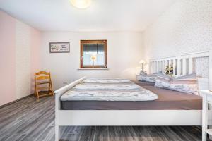 a bedroom with a white bed and a window at Ferienwohnung Eichenhof in Blankensee