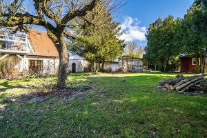 a yard with a tree and a house at Ferienwohnung Eichenhof in Blankensee