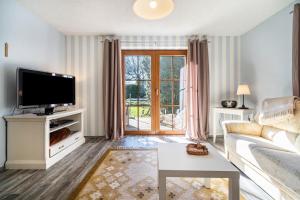 a living room with a couch and a tv at Ferienwohnung Eichenhof in Blankensee