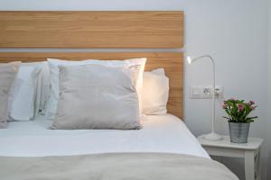 a bed with white pillows and a wooden headboard at Casa Majina in El Islote