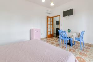 a bedroom with a bed and a table and chairs at Villa Bludea - Salento in Torre Lapillo