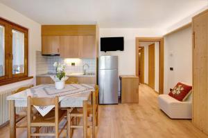 a kitchen and dining room with a table and a refrigerator at Appartamenti Vittoria Bilo in Valfurva