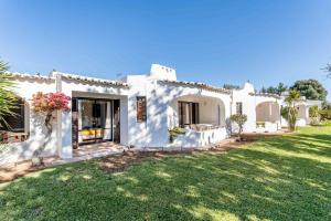a white house with a lawn in front of it at Casa N's in Albufeira