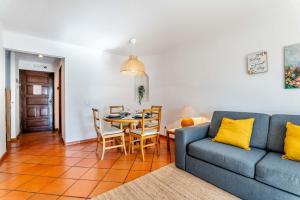 a living room with a blue couch and a table at Casa N's in Albufeira