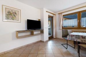 a living room with a flat screen tv on a wall at Apartments Antersi Claudia in San Vigilio Di Marebbe
