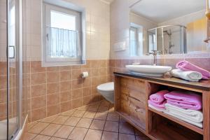 a bathroom with a sink and a toilet and a mirror at Apartments Antersi Claudia in San Vigilio Di Marebbe +21 photos