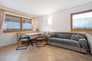 a living room with a couch and a table at Apartments Antersi Claudia in San Vigilio Di Marebbe